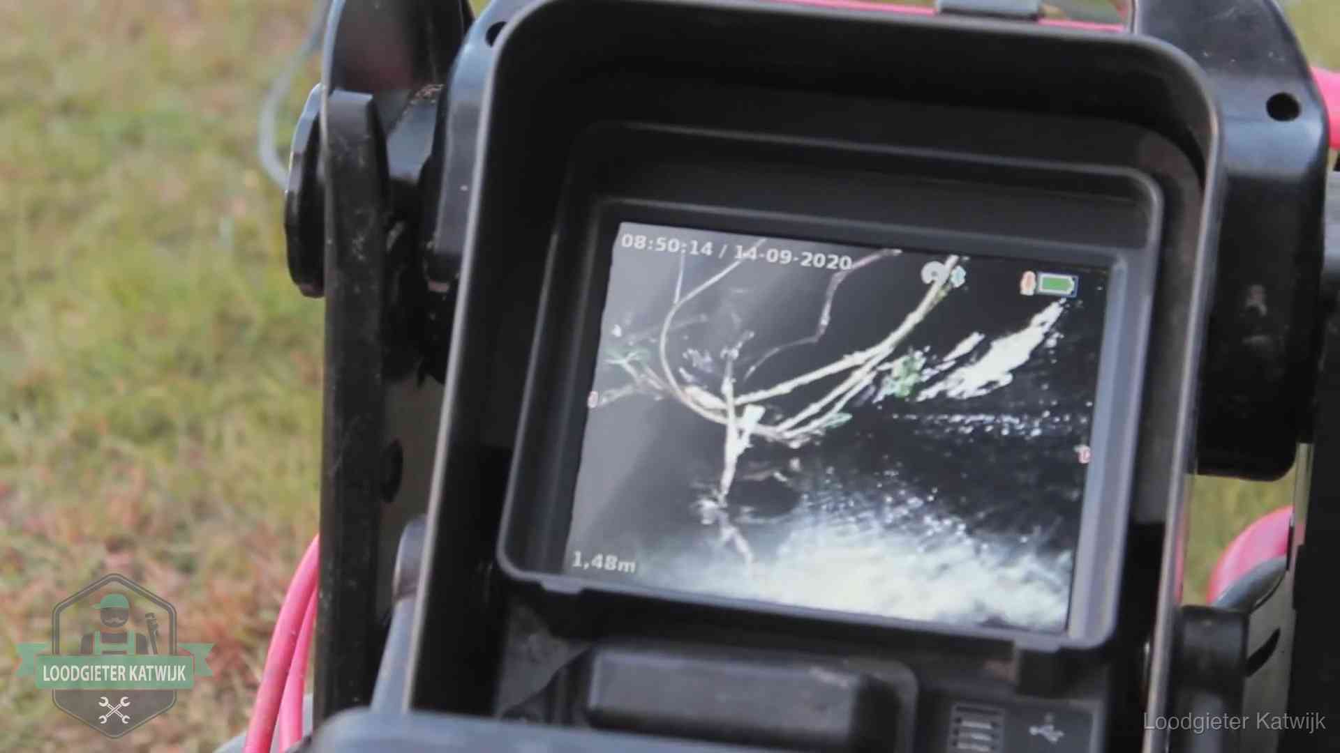 Monitor van een rioolcamera toont wortelingroei in de rioolbuis bij een woning in Katwijk
