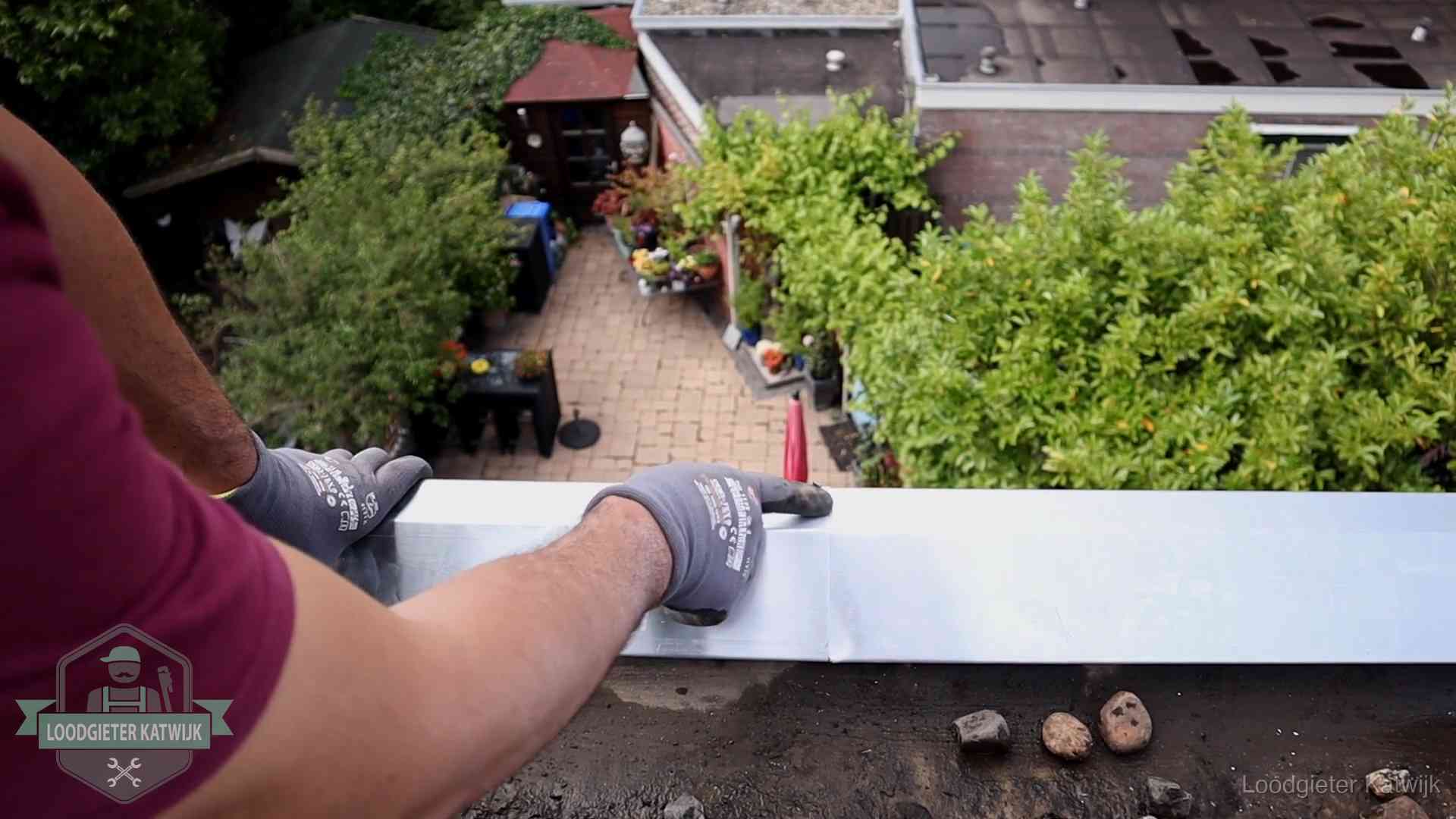Daklekkage geregeld in Katwijk Vakman plaatst een daktrim op de dakrand van een woning in Katwijk