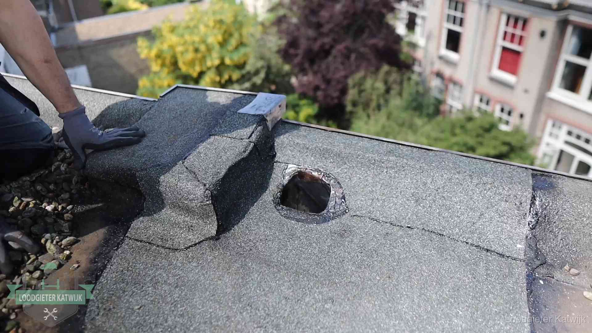 Daklekkage-inspectie op een plat dak in Katwijk Loodgieter inspecteert een beschadigd bitumen plat dak tijdens een daklekkage-inspectie in Katwijk