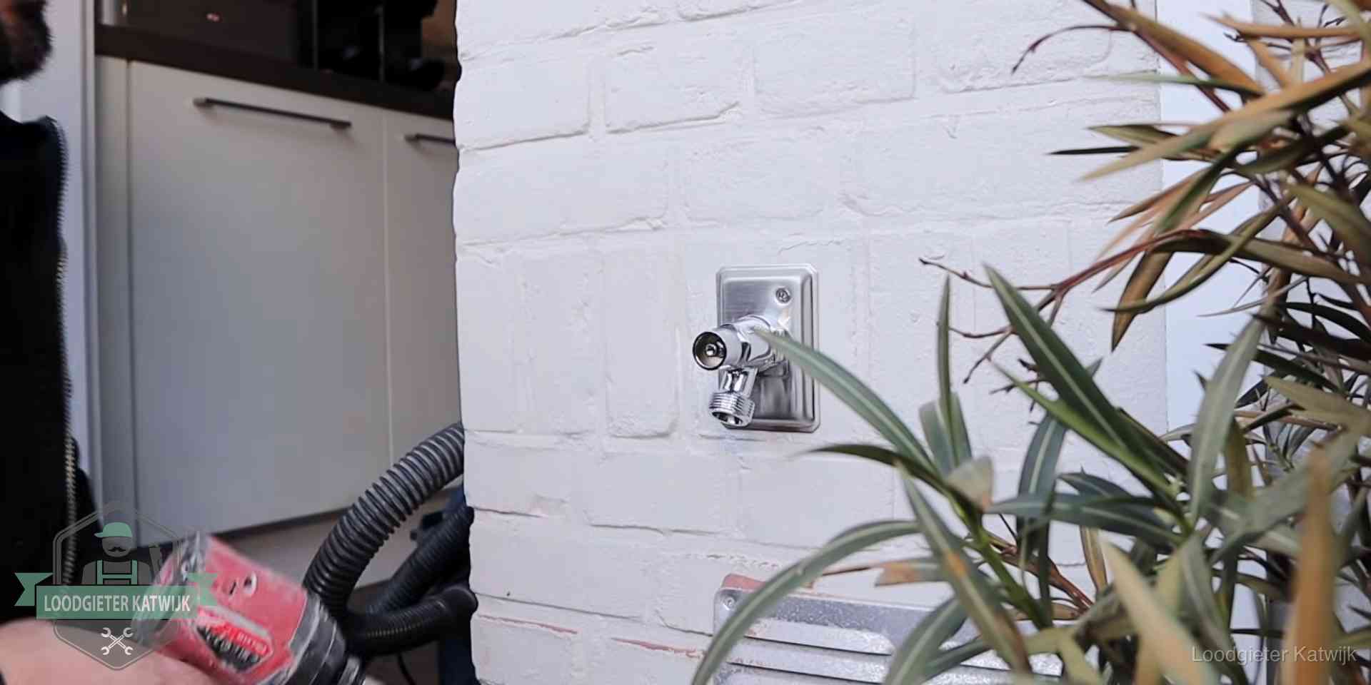 Daklek of leidinglek testen in Katwijk Chromen kraan op een muurplaat bij een woning in Katwijk, dichtdraaien is stap een van de lektest