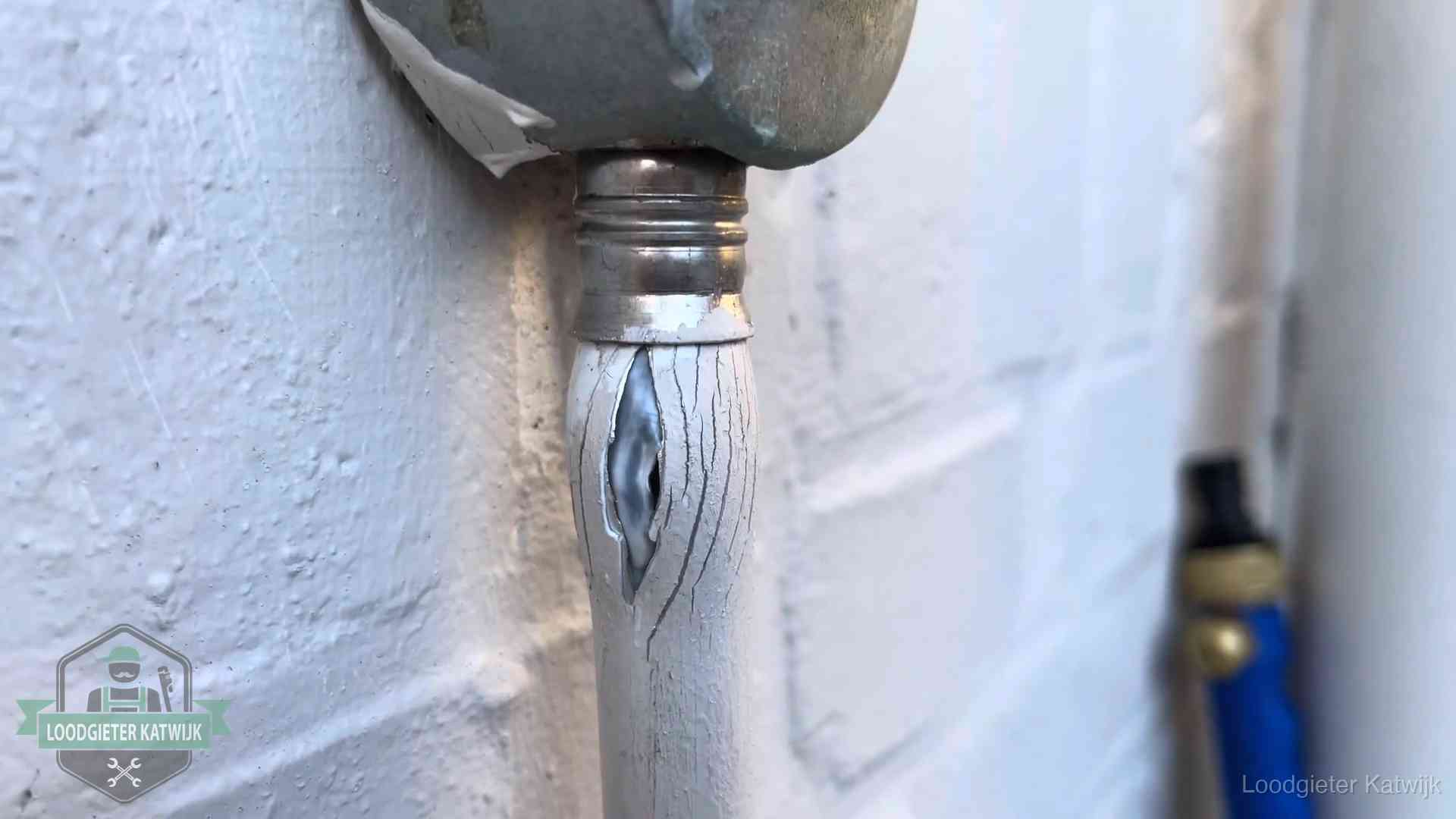 Oude waterleiding in Katwijk waar de verf openscheurt, een stille aanwijzing voor een beginnend lek
