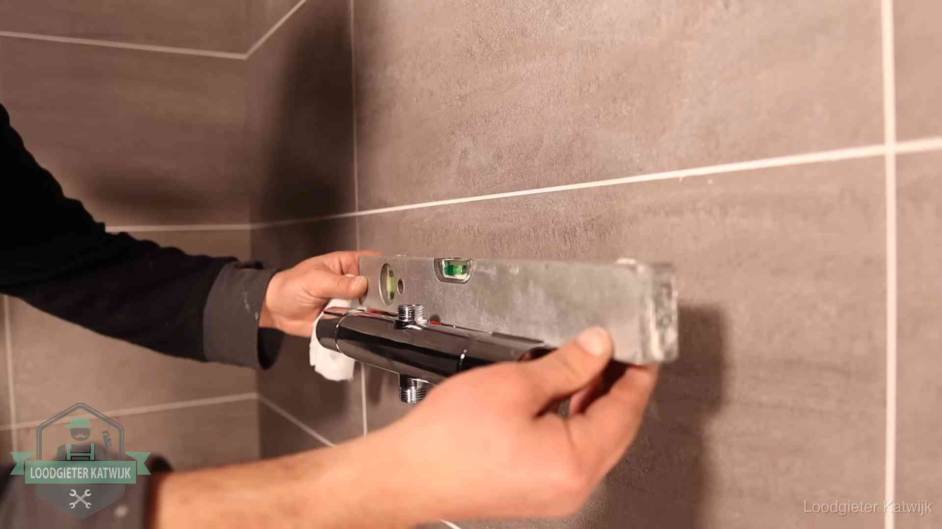 Loodgietersbedrijf voor sanitair in Katwijk Loodgieter lijnt een douchekraan uit met een waterpas in een woning in Katwijk