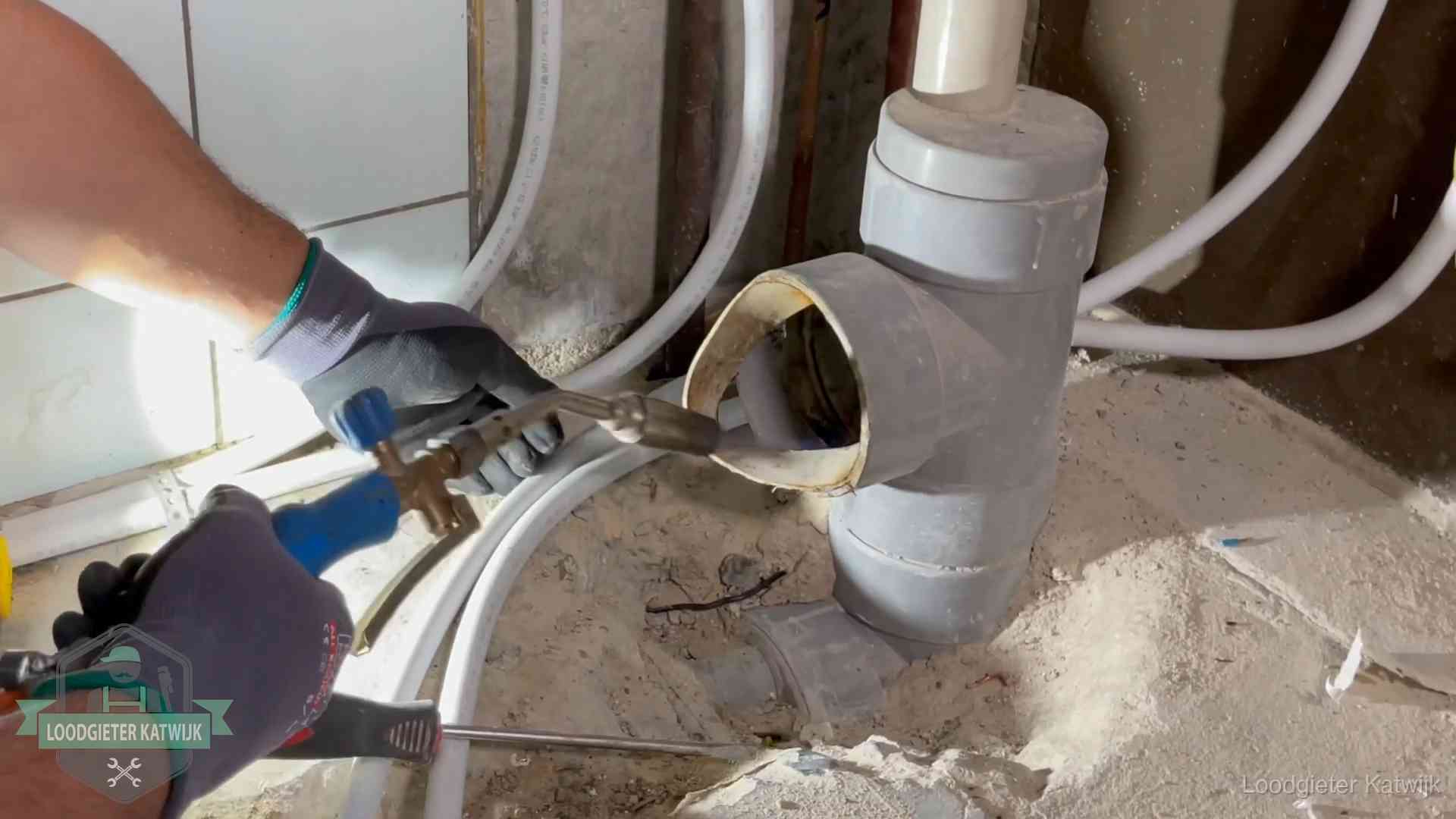 Vakmanschap van onze loodgieters in Katwijk Loodgieter werkt met brander en messing kraanwerk aan leidingen in Katwijk