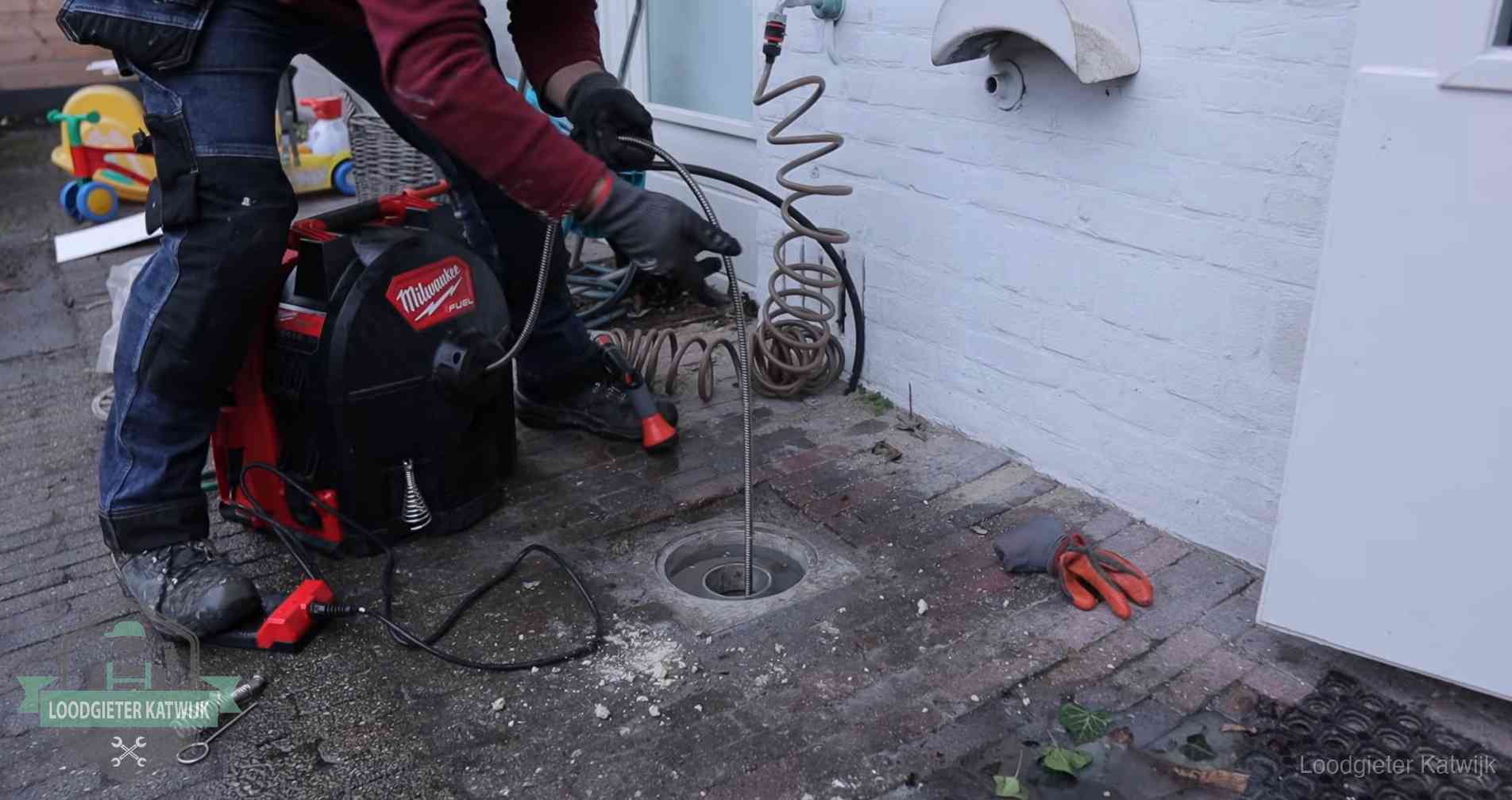 Ontstoppingsputje in de bestrating naast de gevel van een woning in Katwijk