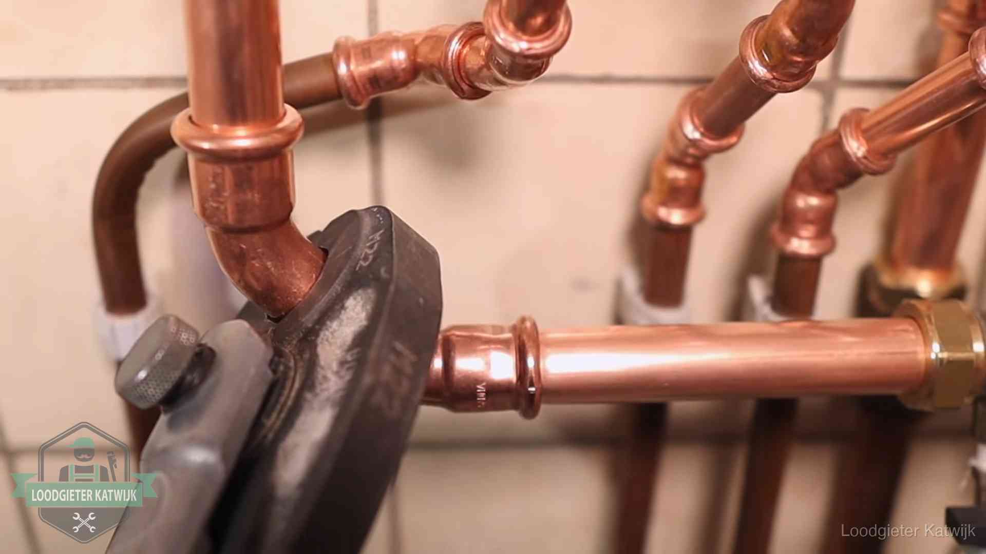 Werkwijze van ons loodgietersbedrijf in Katwijk Persmachine perst een koperen fitting op nieuw leidingwerk in Katwijk