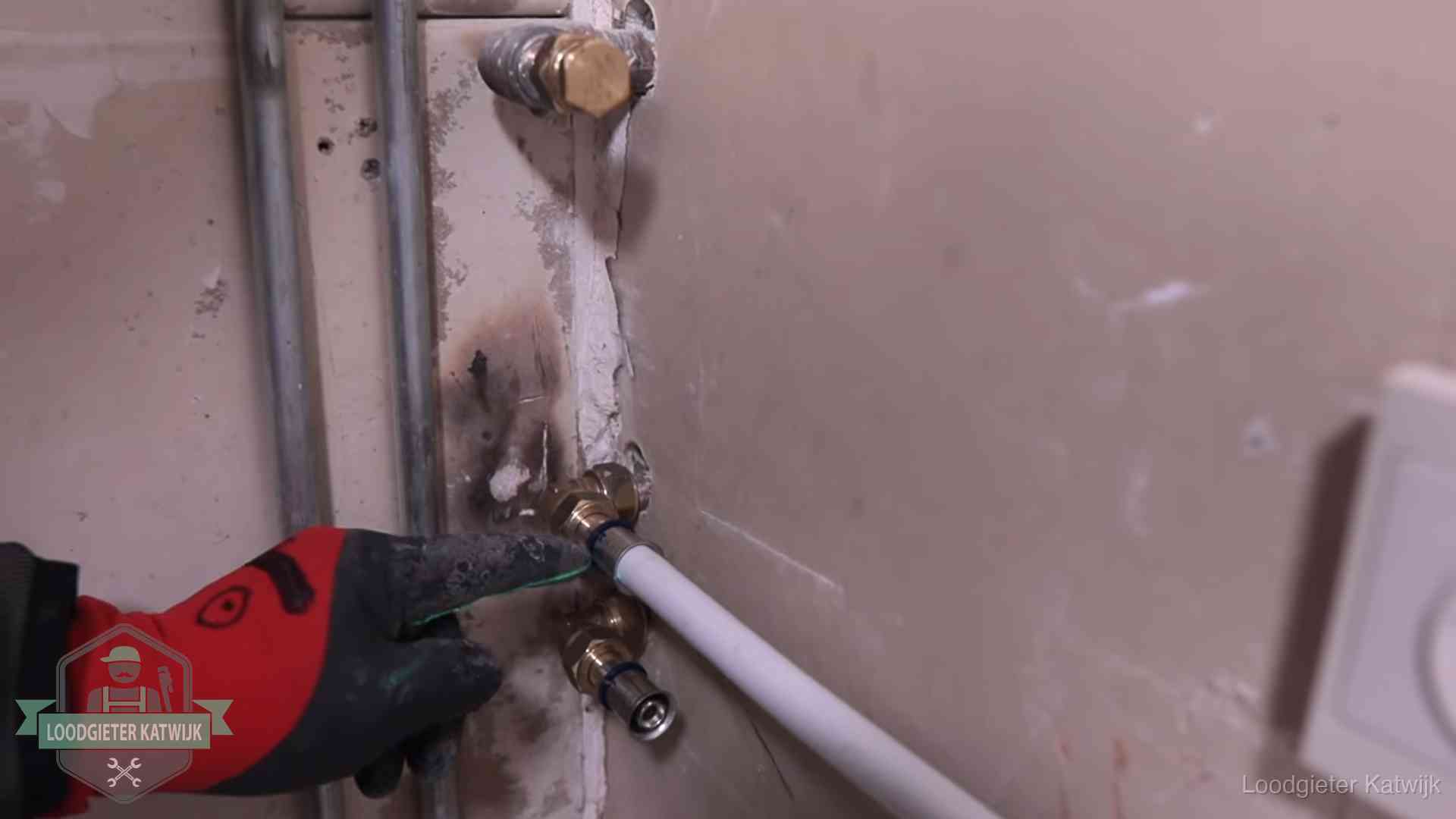 Garantie op loodgieterswerk in Katwijk Loodgieter wijst de persfitting op nieuwe muuraansluitingen aan in een woning in Katwijk
