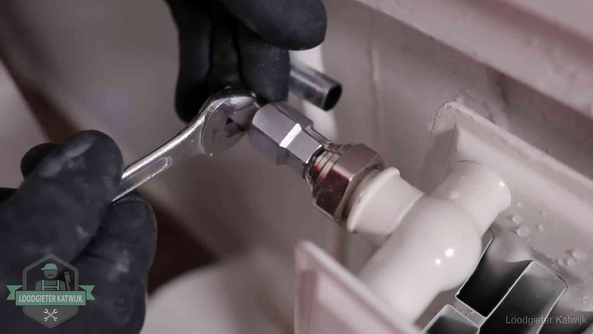 Radiatoren en waterzijdig inregelen in Katwijk Steeksleutel draait een wartelkoppeling op een radiatorkraan aan in Katwijk