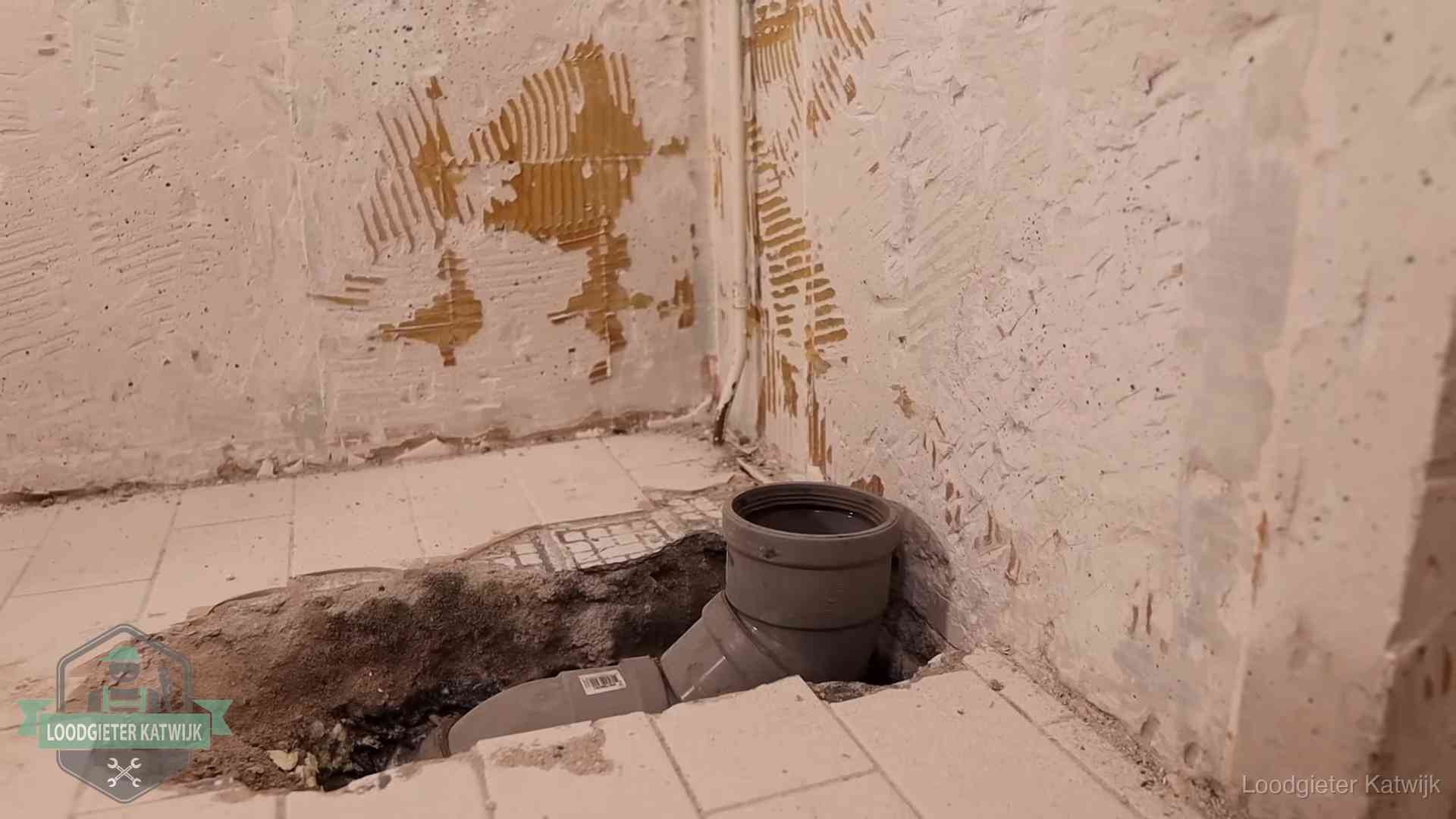Opengebroken vloer met een nieuwe pvc-rioolbocht in een gegraven sleuf in Katwijk