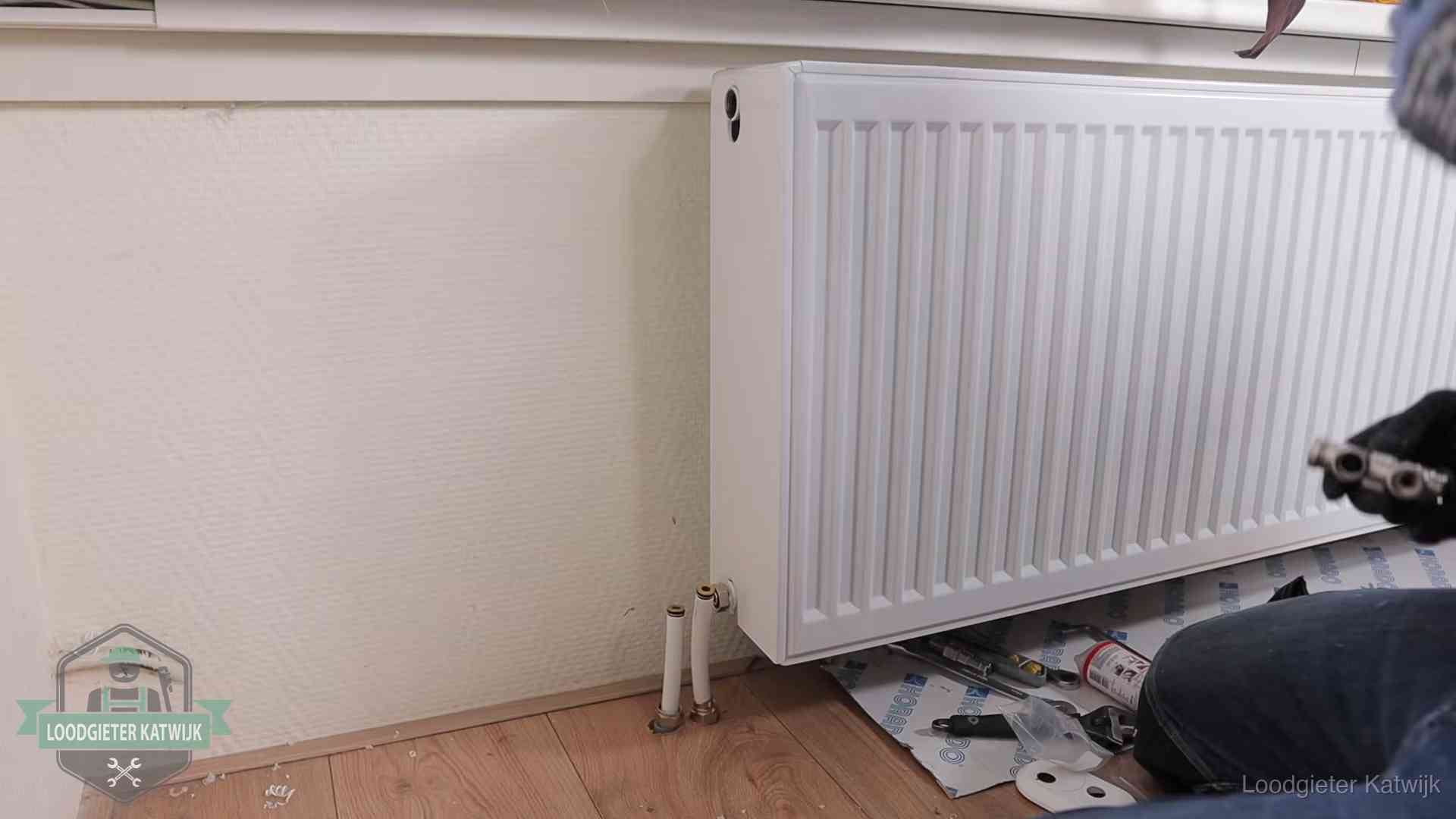 Verwarming per wijk in Katwijk Nieuw gemonteerde radiator in een woonkamer in Katwijk