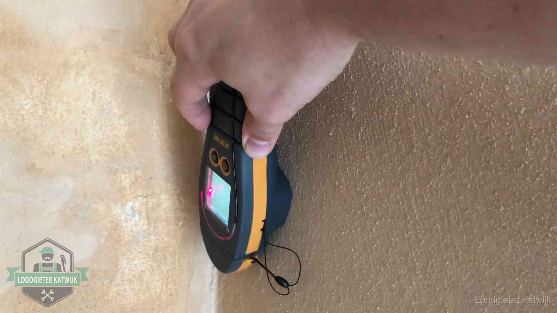 Daklekkage opsporen zonder hakwerk in Katwijk Vochtmeter tegen een muur met vochtplekken tijdens het opsporen van een daklekkage in Katwijk