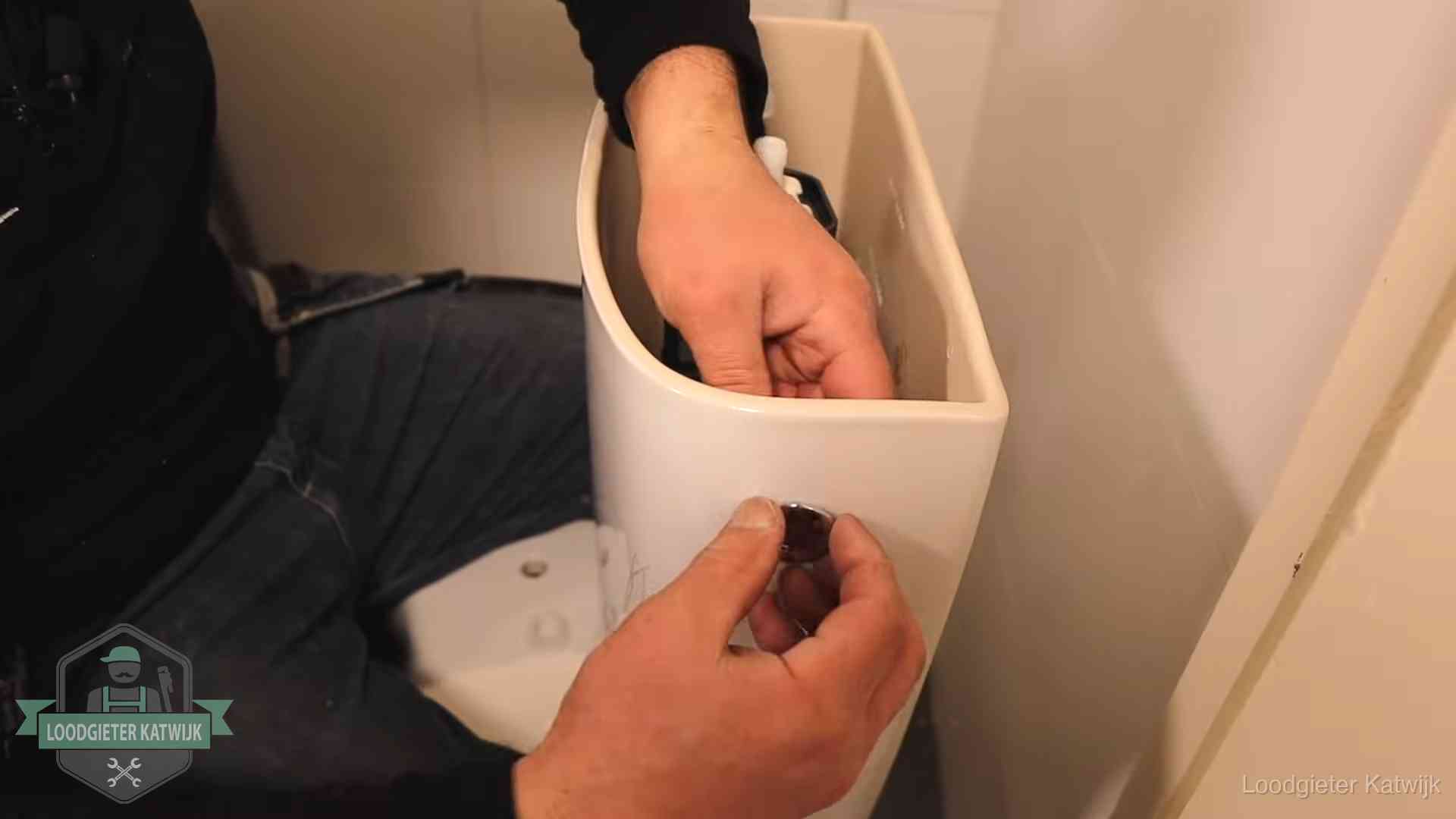 Je wc verstoppingsvrij houden in Katwijk Drukknop van een duoblok-stortbak wordt gemonteerd bij een toilet in Katwijk